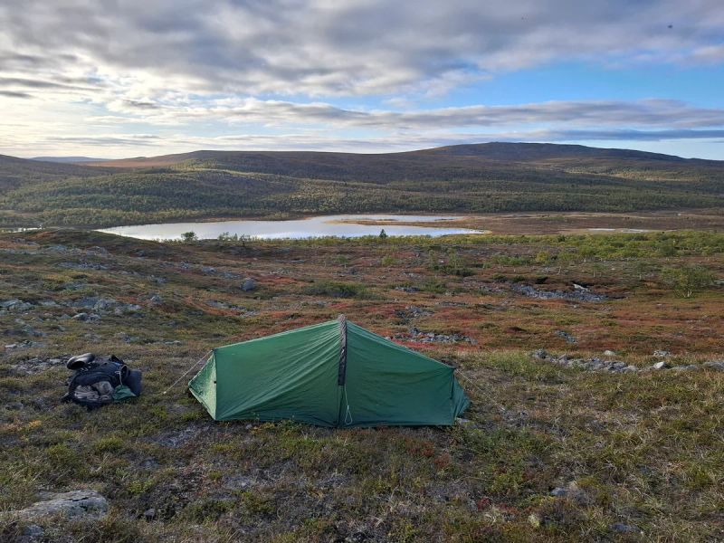 Teltta avarassa tunturimaastossa. Taustalla järvi.